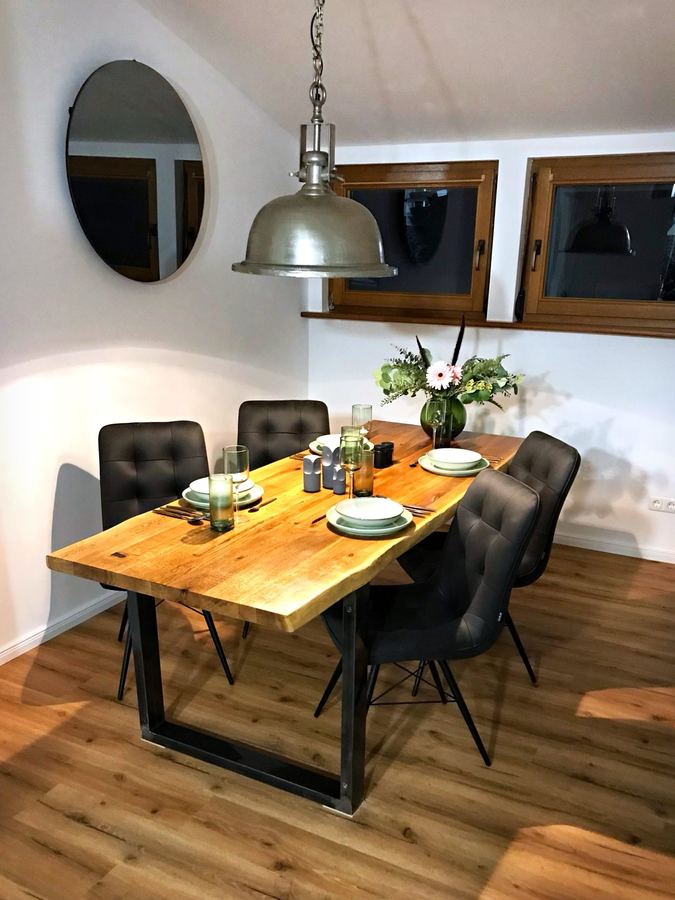 Gedeckter Esstisch aus Holz mit vier Stühlen
