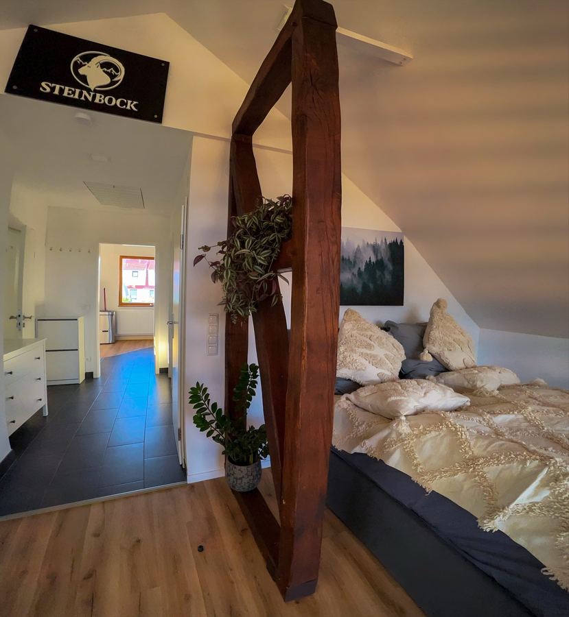 Schlafbereich mit 160 cm Boxspringbett und Holzbalken